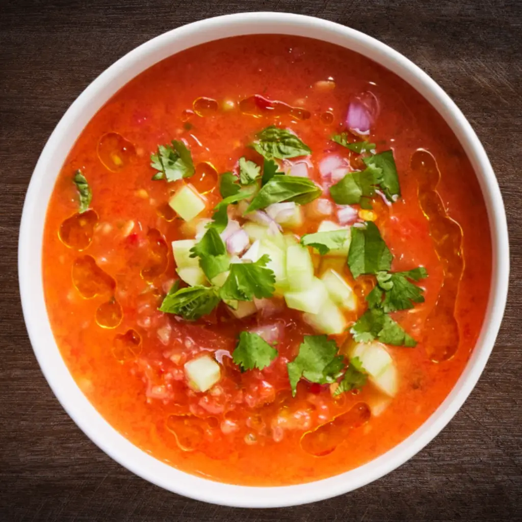 Roasted gazpacho topped with cucumber, red onion, fresh herbs, and olive oil